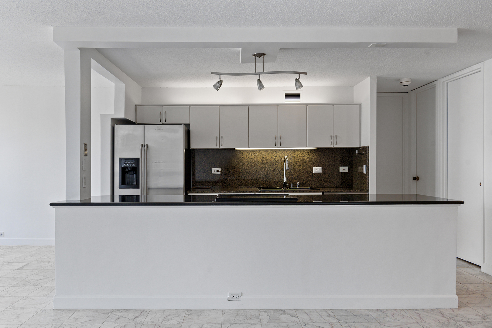 360 East Randolph Street, Unit 3105 Chicago, IL 60601 - Photo 6 of 28 a kitchen with stainless steel appliances granite countertop a refrigerator a stove and white cabinets
