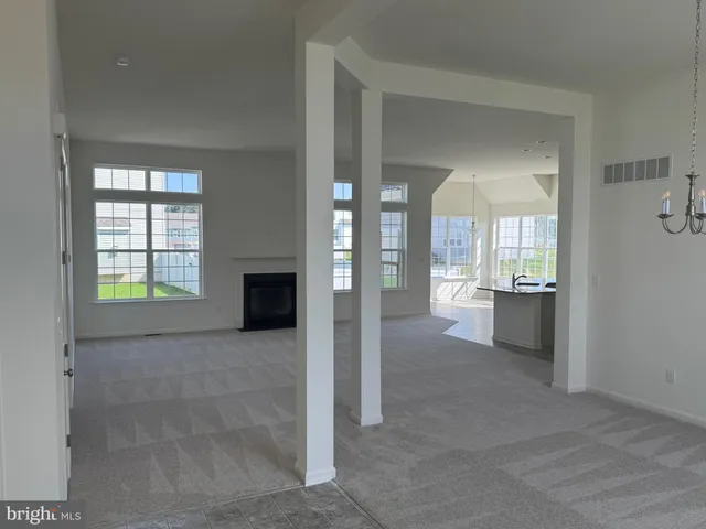 a view of a hallway with wooden floor and a living room