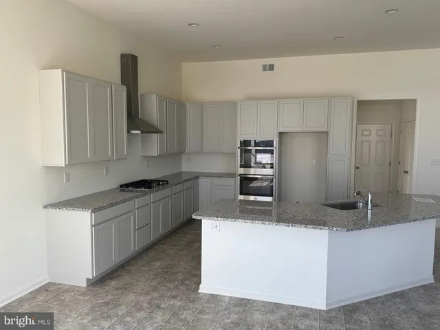 a kitchen with stainless steel appliances granite countertop a sink and a stove