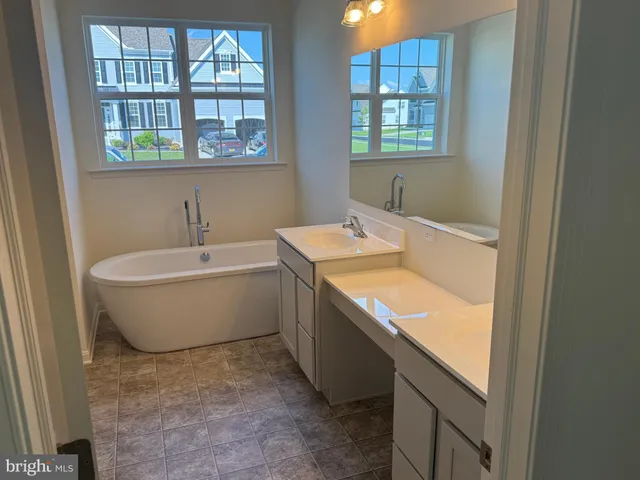 a bathroom with a tub sink and mirror