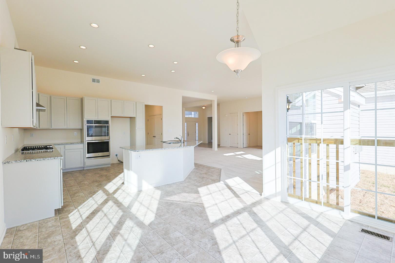 910 Weatherstone Lane Felton, DE 19943 - Photo 10 of 22 a large white kitchen with wooden floor and a refrigerator
