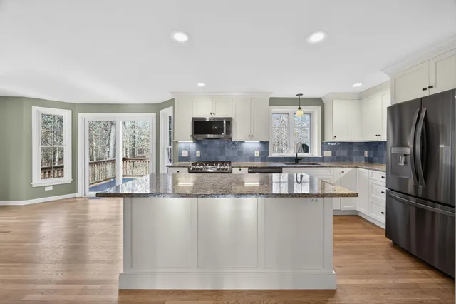 a large kitchen with a large window and stainless steel appliances
