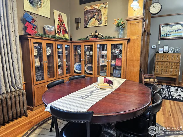 a spacious bedroom with a bed a dresser and wooden floor