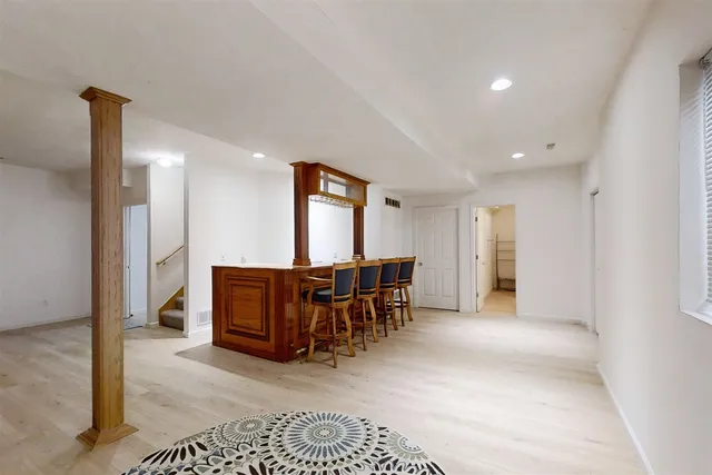 a living room with furniture a dining table and a refrigerator