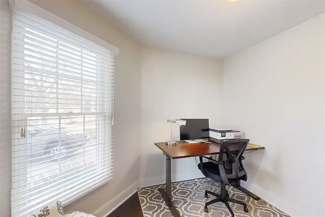 a view of a workspace with furniture and a window