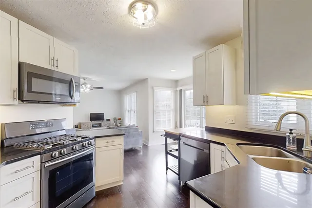 a kitchen with stainless steel appliances granite countertop a stove a sink and a microwave