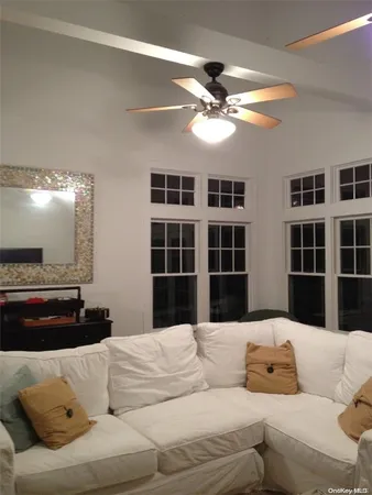 a living room with furniture window and kitchen view