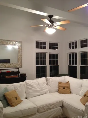 a living room with furniture window and kitchen view