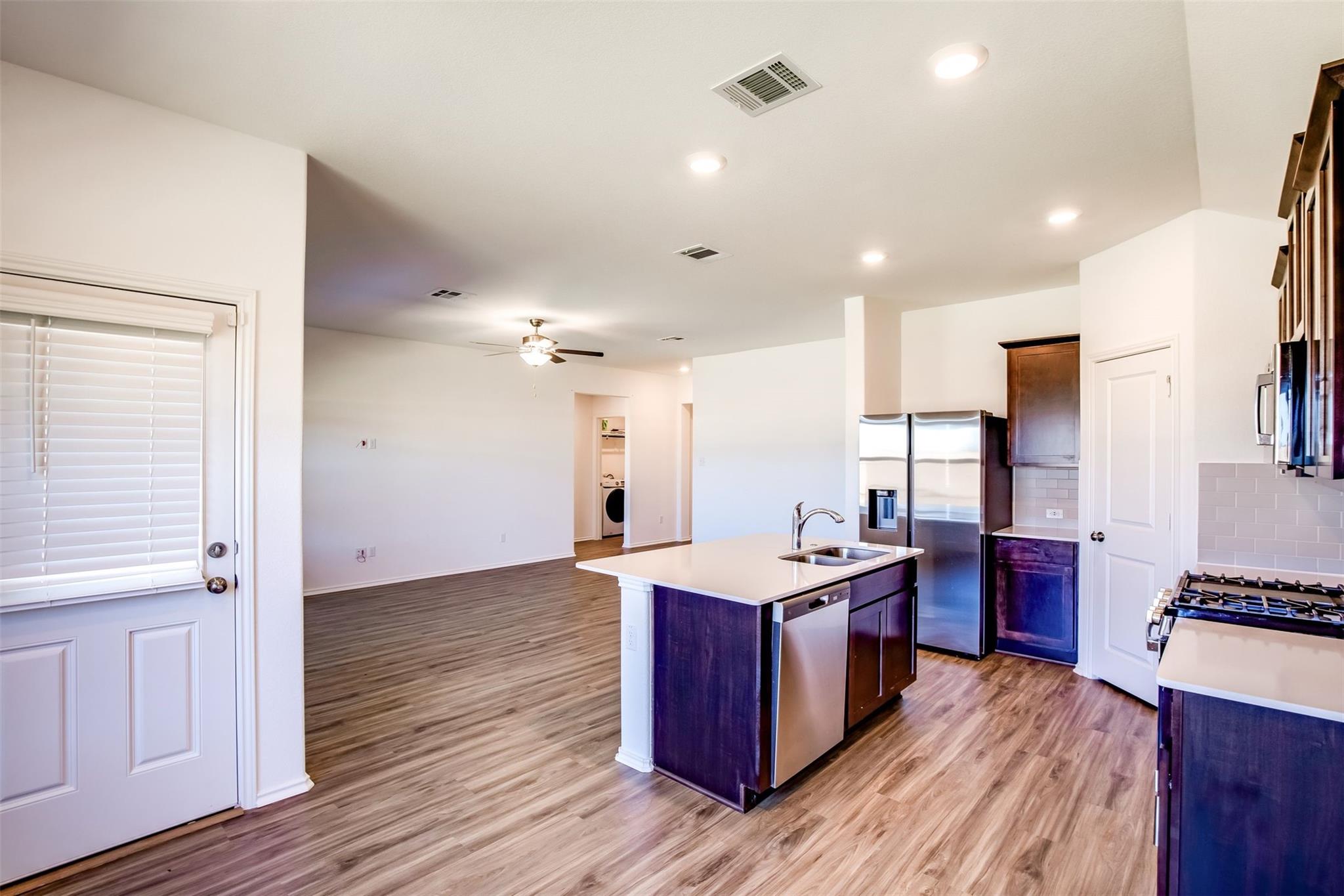 614 Milliner Loop Hutto, TX 78634 - Photo 17 of 25 An open concept design seamlessly connects the kitchen with a central island and a spacious living area.