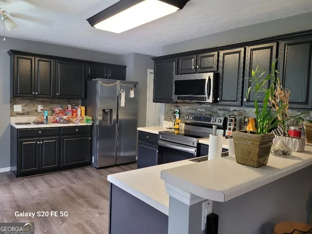 a kitchen with stainless steel appliances wooden cabinets and refrigerator