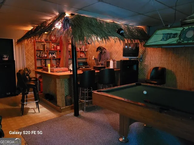 a backyard of a house with barbeque oven table and chairs