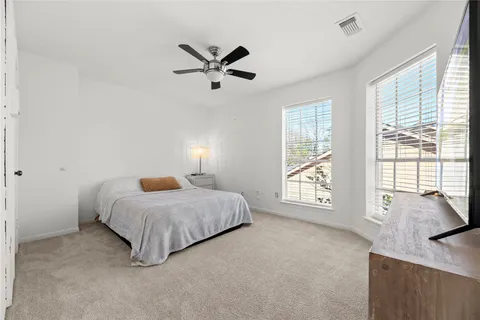 a spacious bedroom with a bed and a large window