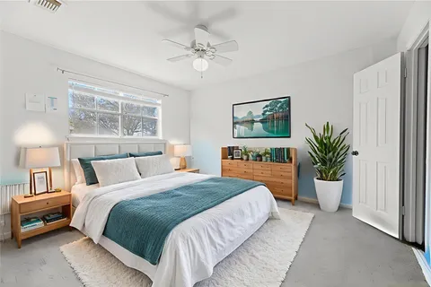 a bedroom with a large bed and a chandelier