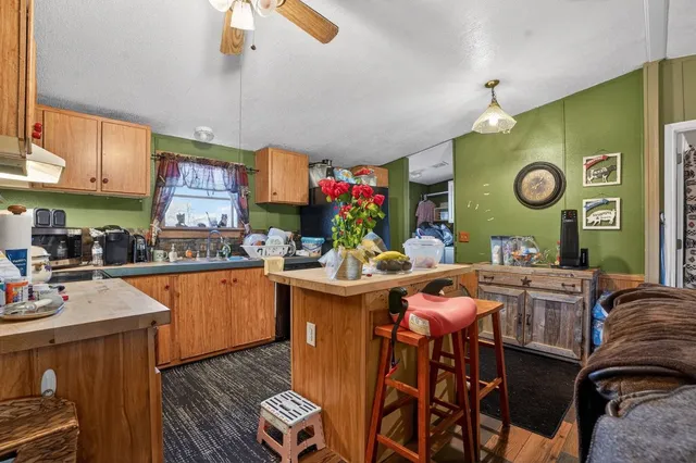 a kitchen with stainless steel appliances granite countertop a refrigerator a stove a sink dishwasher and a dining table with chairs