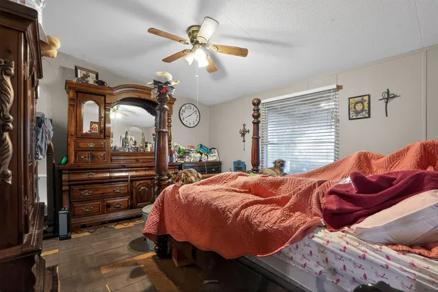 a bedroom with a bed and a ceiling fan