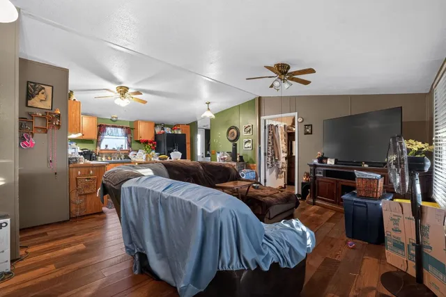 a living room with furniture a flat screen tv and kitchen view