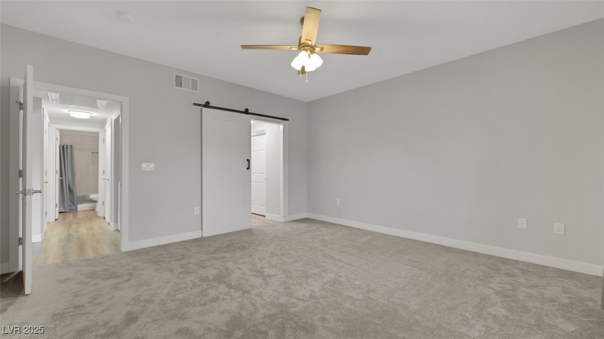 4921 Black Bear Road, Unit 104 Las Vegas, NV 89149 - Photo 16 of 35 Primary Suite with Ceiling Fan and Barn Door separating Ensuite