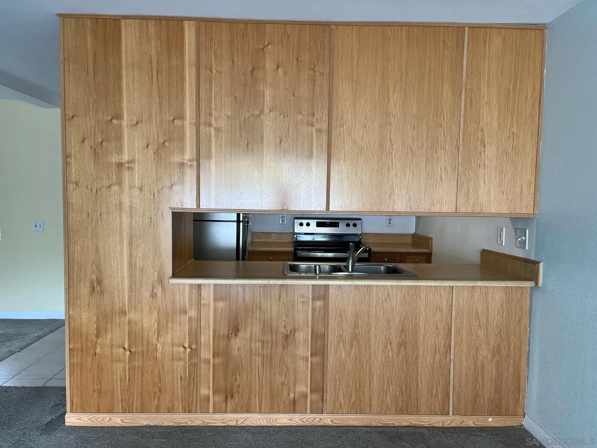 8332 Regents Road, Unit 1M San Diego, CA 92122 - Photo 4 of 18 a kitchen with wooden cabinets and stainless steel appliances