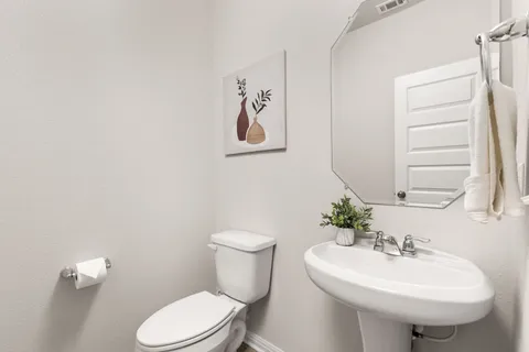 a bathroom with a sink toilet and a mirror