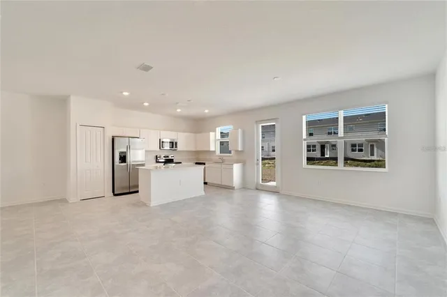 a large white kitchen with cabinets