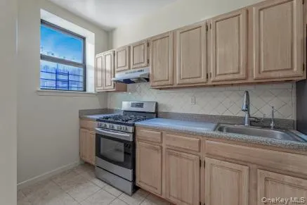 a kitchen with granite countertop white cabinets and stainless steel appliances