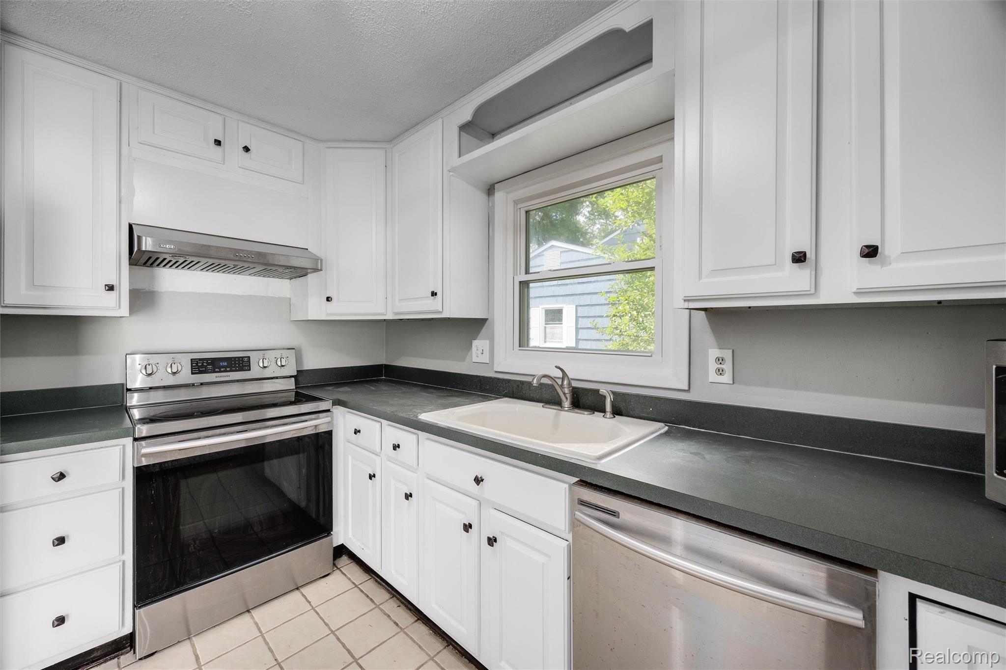4942 Butler Drive Troy, MI 48085 - Photo 10 of 33 Kitchen featuring white shaker-style cabinetry, dark countertops, and stainless steel appliances