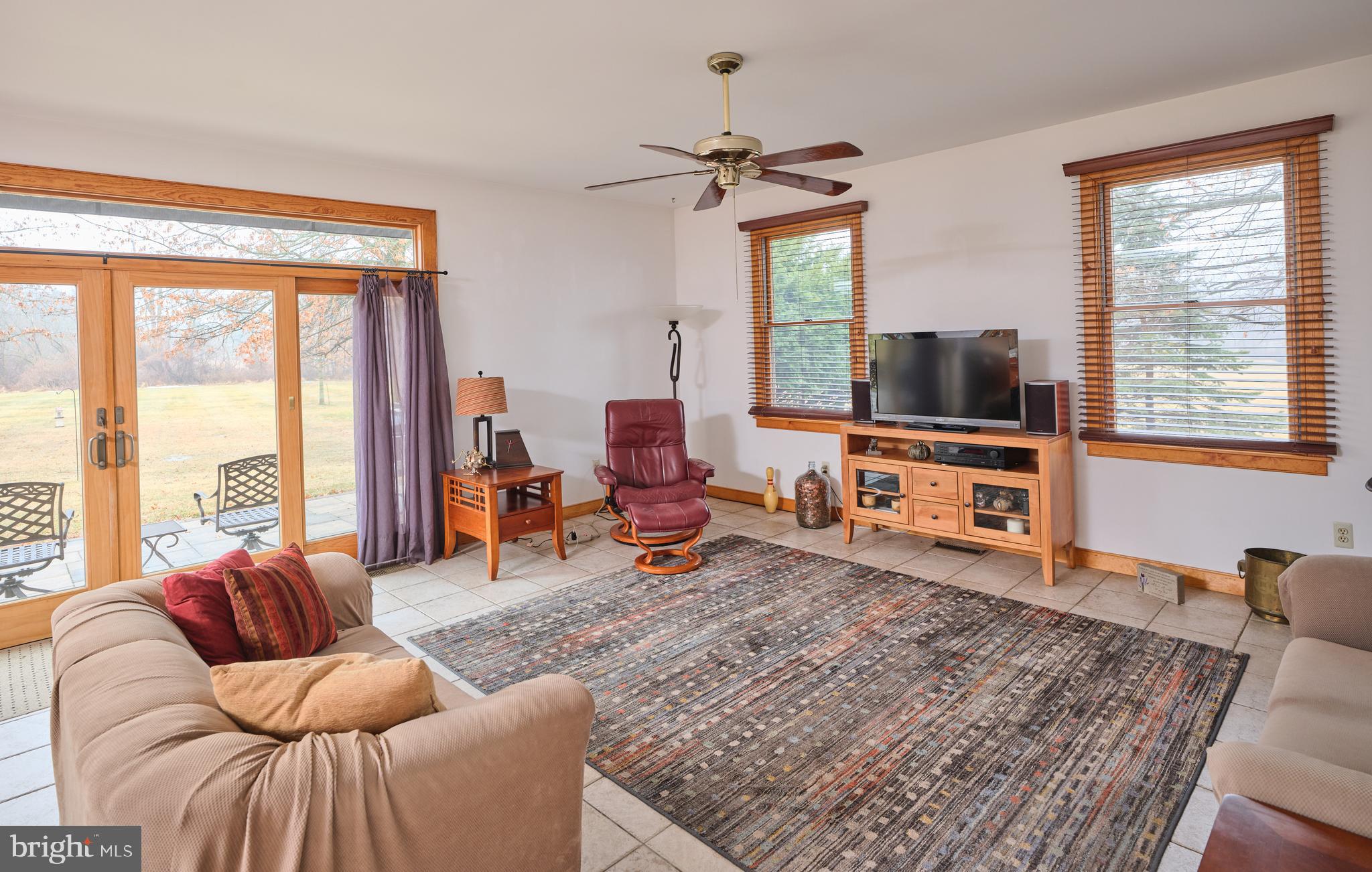 810 Callowhill Road Perkasie, PA 18944 - Photo 12 of 36 a living room with furniture a flat screen tv and a floor to ceiling window
