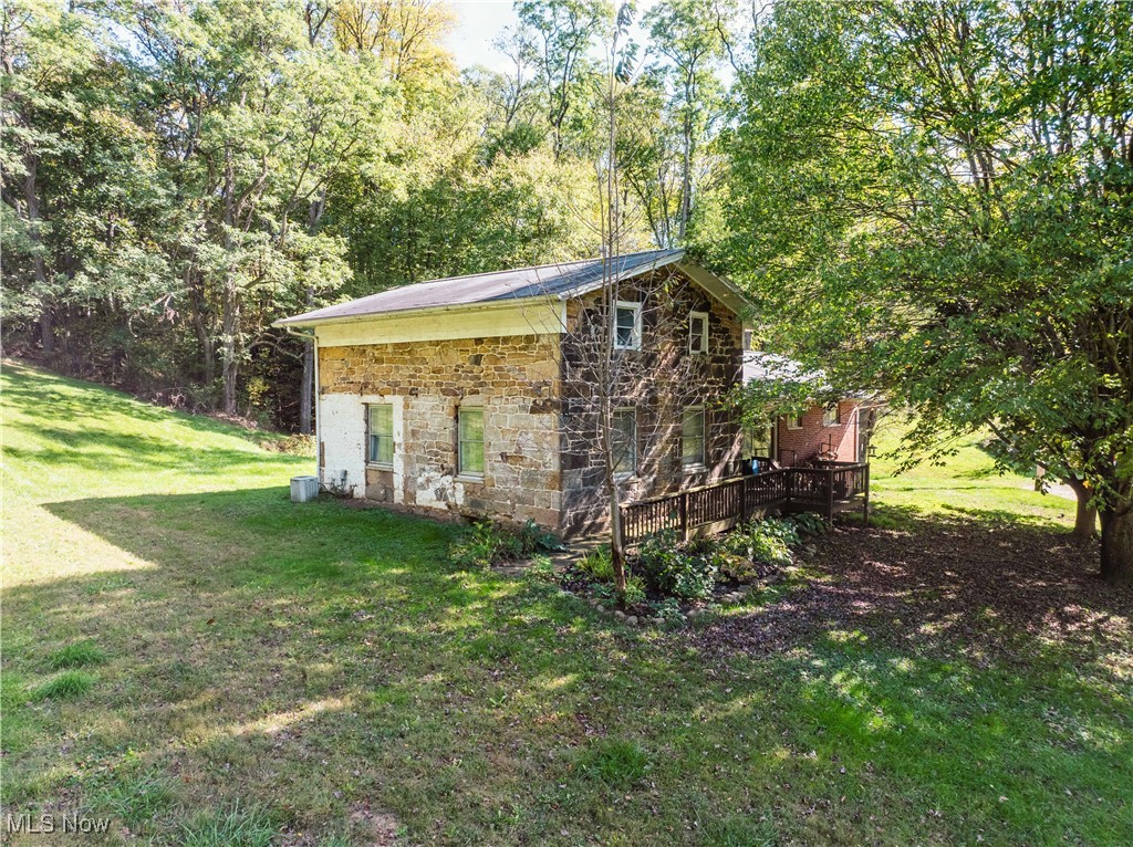 3261 Moffett Road Lucas, OH 44843 - Photo 4 of 40 View of side of home with a yard, stone siding, and a deck