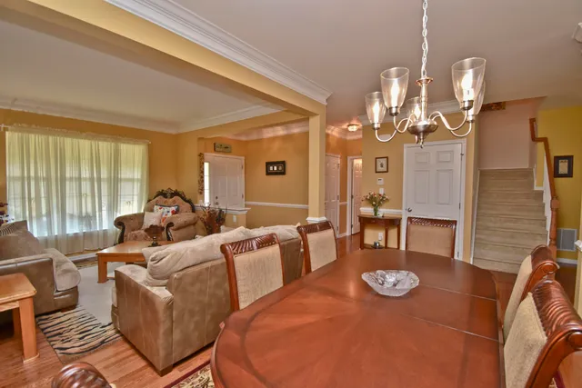 a living room with furniture kitchen view and large windows