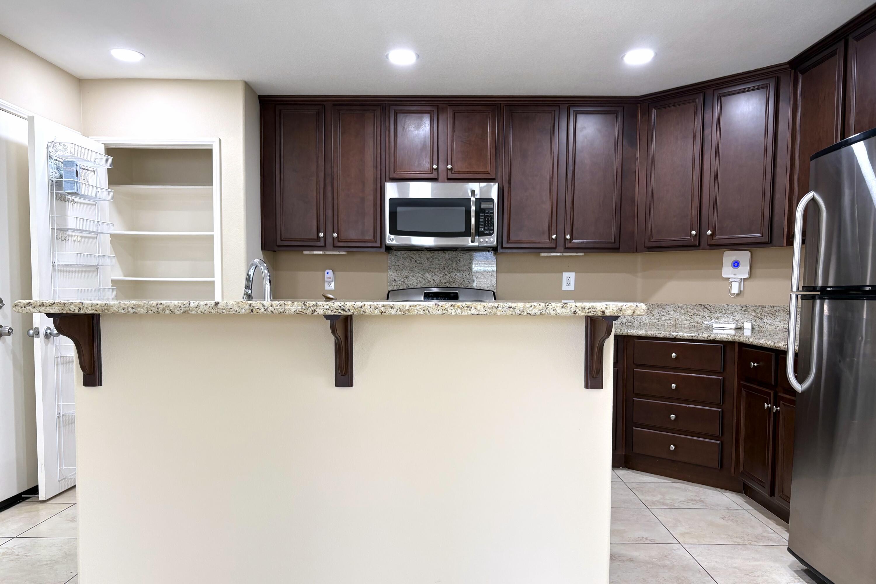 84175 Tramonto Way Indio, CA 92203 - Photo 6 of 22 a kitchen with stainless steel appliances granite countertop wooden cabinets a stove top oven a sink and dishwasher
