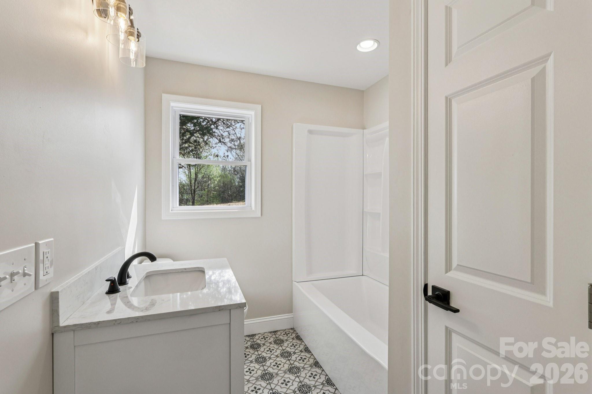 1403 Dudley Shoals Road Granite Falls, NC 28630 - Photo 20 of 20 a bathroom with a granite countertop sink a toilet a mirror and shower