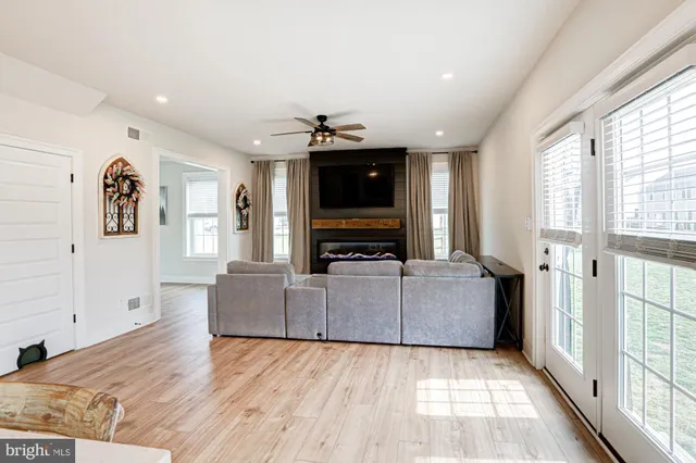 a view of a dining room and livingroom with furniture wooden floor a chandelier