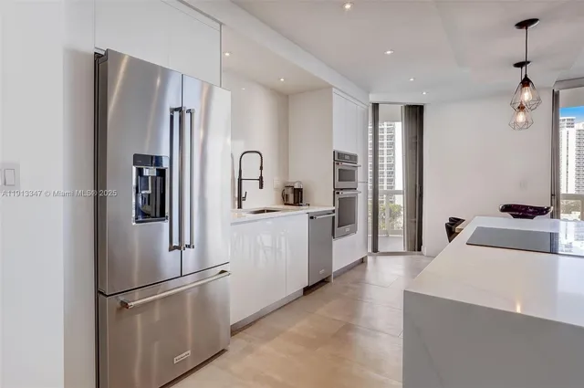 a kitchen with stainless steel appliances a refrigerator sink and cabinets
