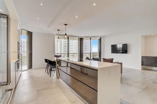 a view of kitchen with kitchen island dining table and chairs