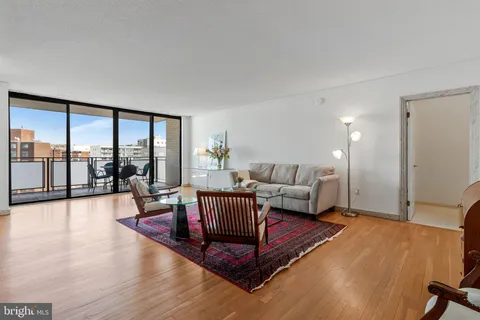 a living room with furniture a rug and a book shelf