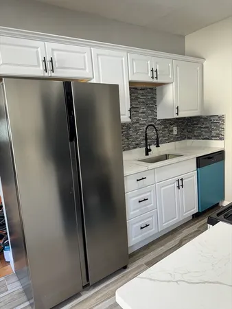 a kitchen with stainless steel appliances a refrigerator sink and cabinets