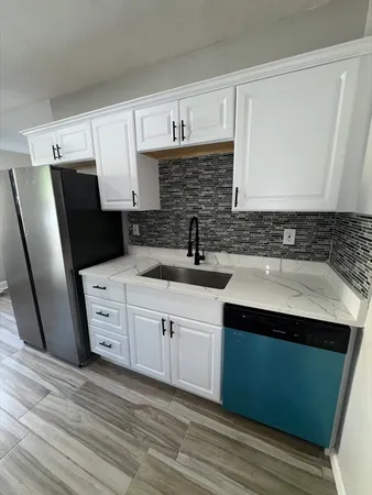 a kitchen with stainless steel appliances a sink stove and refrigerator
