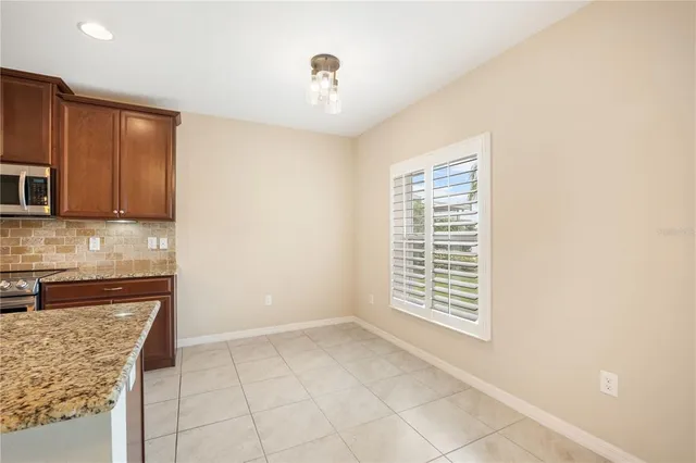 a view of kitchen with granite countertop cabinets and window
