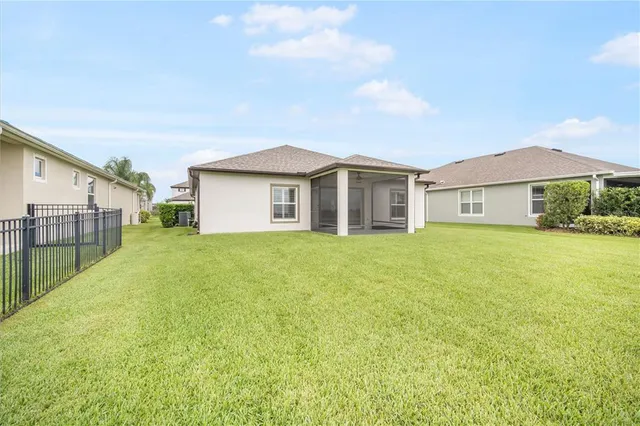 a view of a house with a big yard and large trees