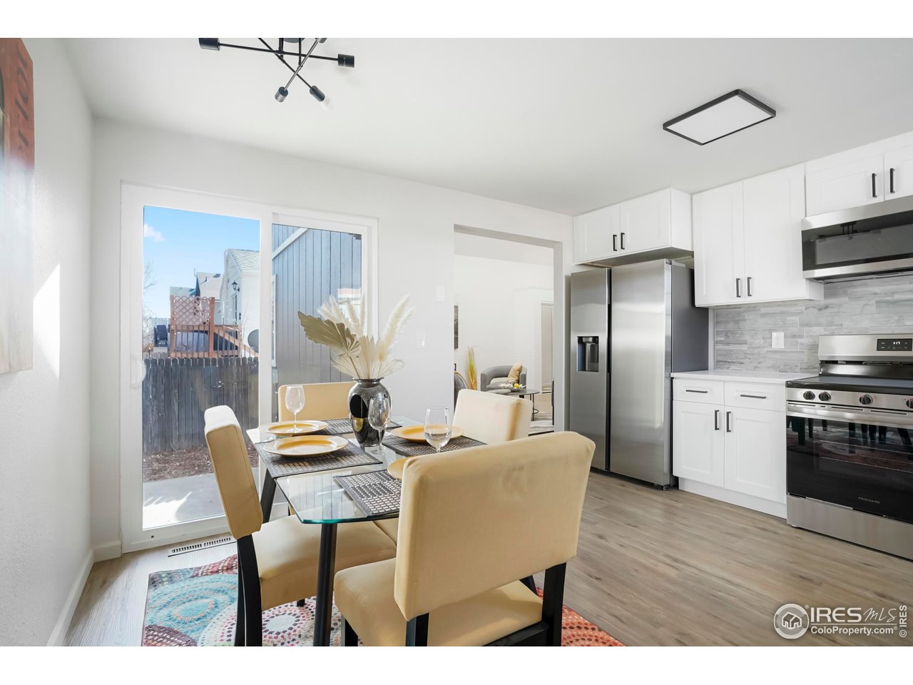 1356 Emery Street Longmont, CO 80501 - Photo 10 of 24 a kitchen with stainless steel appliances kitchen island a table chairs and refrigerator