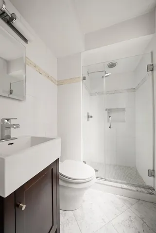 a bathroom with a sink a toilet and shower