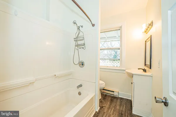 a bathroom with a bathtub a window and a shower
