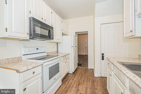 a kitchen with white cabinets sink and stainless steel appliances