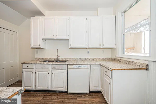 a kitchen with stainless steel appliances granite countertop a sink and dishwasher with white cabinets
