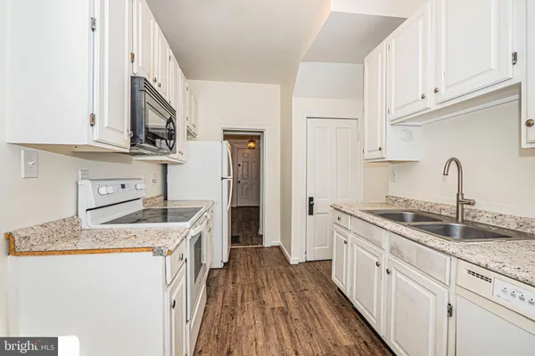 a kitchen with cabinets appliances a sink and a counter space