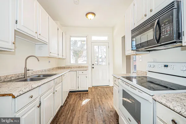 a kitchen with granite countertop cabinets stainless steel appliances and a sink