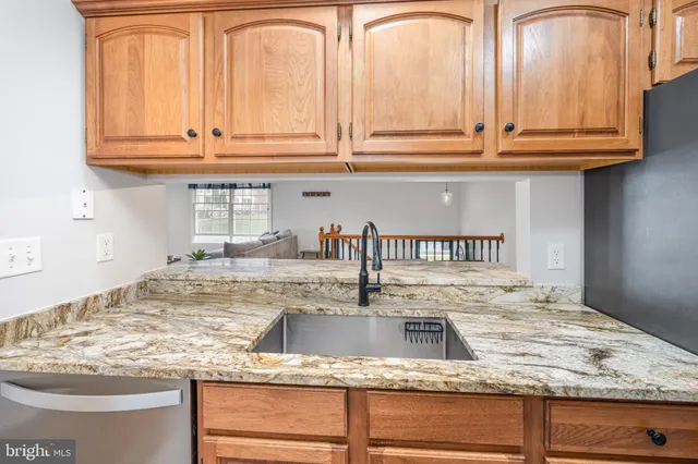 a kitchen with granite countertop a sink and cabinets