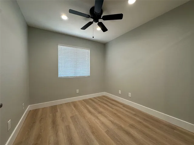 an empty room with a window and a ceiling fan