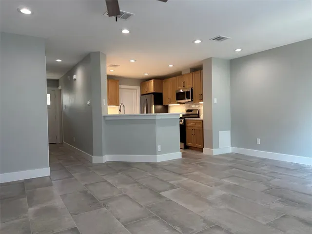 a view of a kitchen with a sink and stainless steel appliances