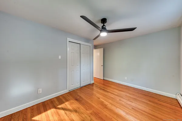 a view of room with wooden floor and ceiling fan